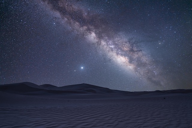 Vast desert landscape under a starry sky, symbolizing adventure and discovery.