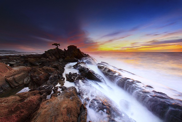 Rugged coastline with waves crashing against cliffs, under a dramatic sky.