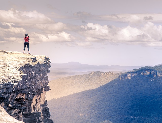 Adventurer looking at a remote mountain range, symbolizing exploration.
