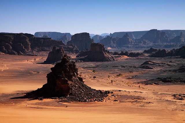 Ancient rock formations in a barren desert landscape, shaped by wind and time.